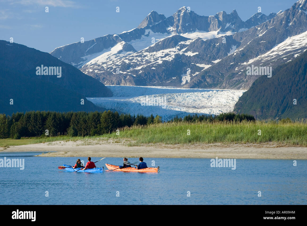 Kayakers kayaking in double sea-kayaks near Juneau in Inside Passage with view of Mendenhall Glacier Alaska Stock Photo