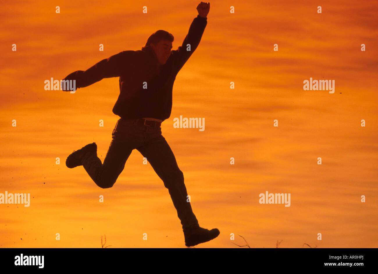 Man Leaping with Excitement Sunset Southcentral Alaska Stock Photo