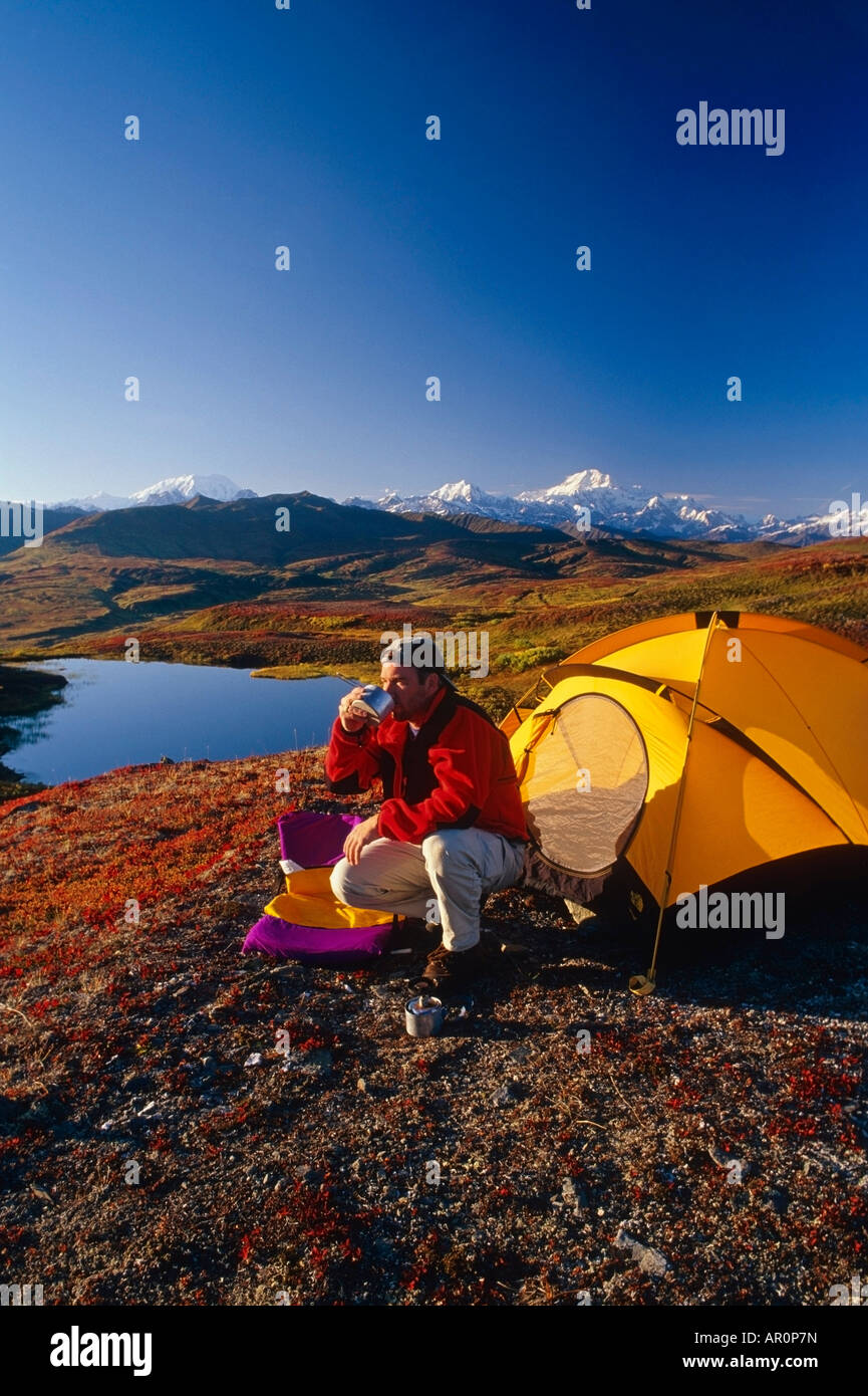 Man Camping & Relaxing  Mt Mckinley Near Pond IN Alaska Stock Photo