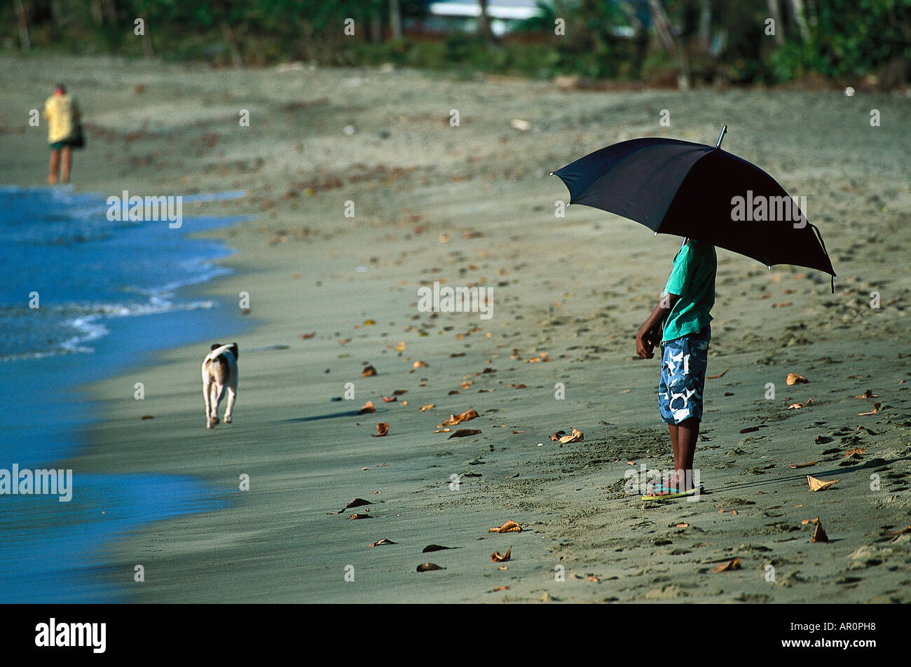 Junge mit Sonnenschirm am Strand, Tobago West Indies, Karibik Stock Photo