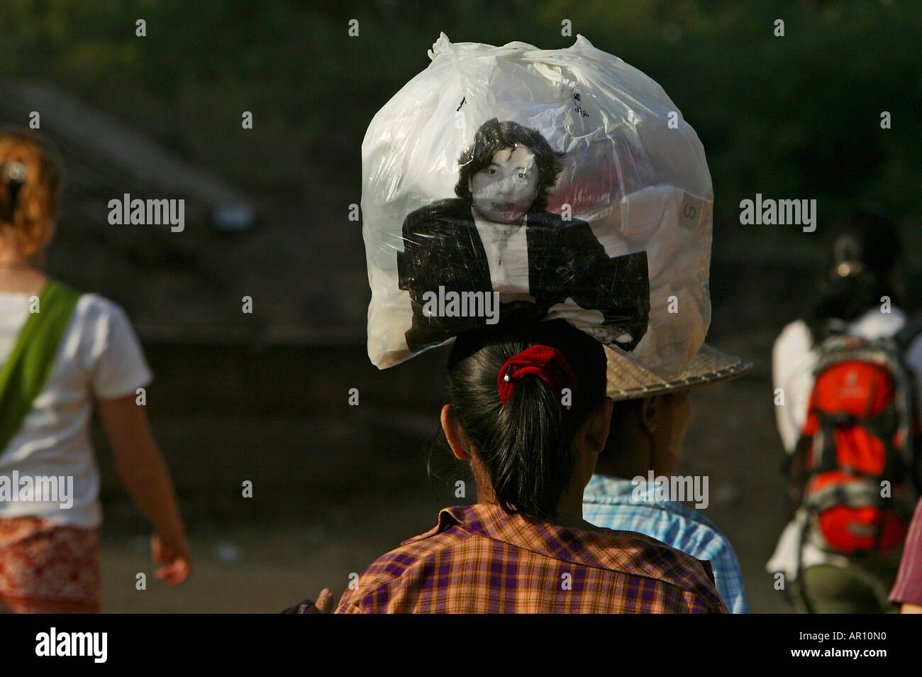 Women balancing plastic bag on head, Frau balanciert eine volle Plastikbeutel auf dem Kopf Stock Photo