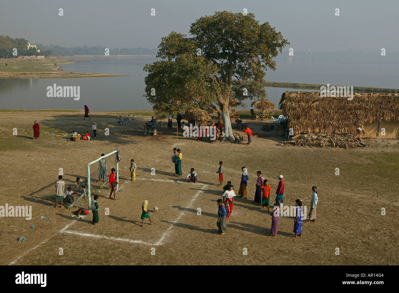 Football seen from U Bein bridge, Fussballspiel neben der U Bein Bruecke, Amarapura, Fussballplatz am Ufer, near Mandalay Stock Photo