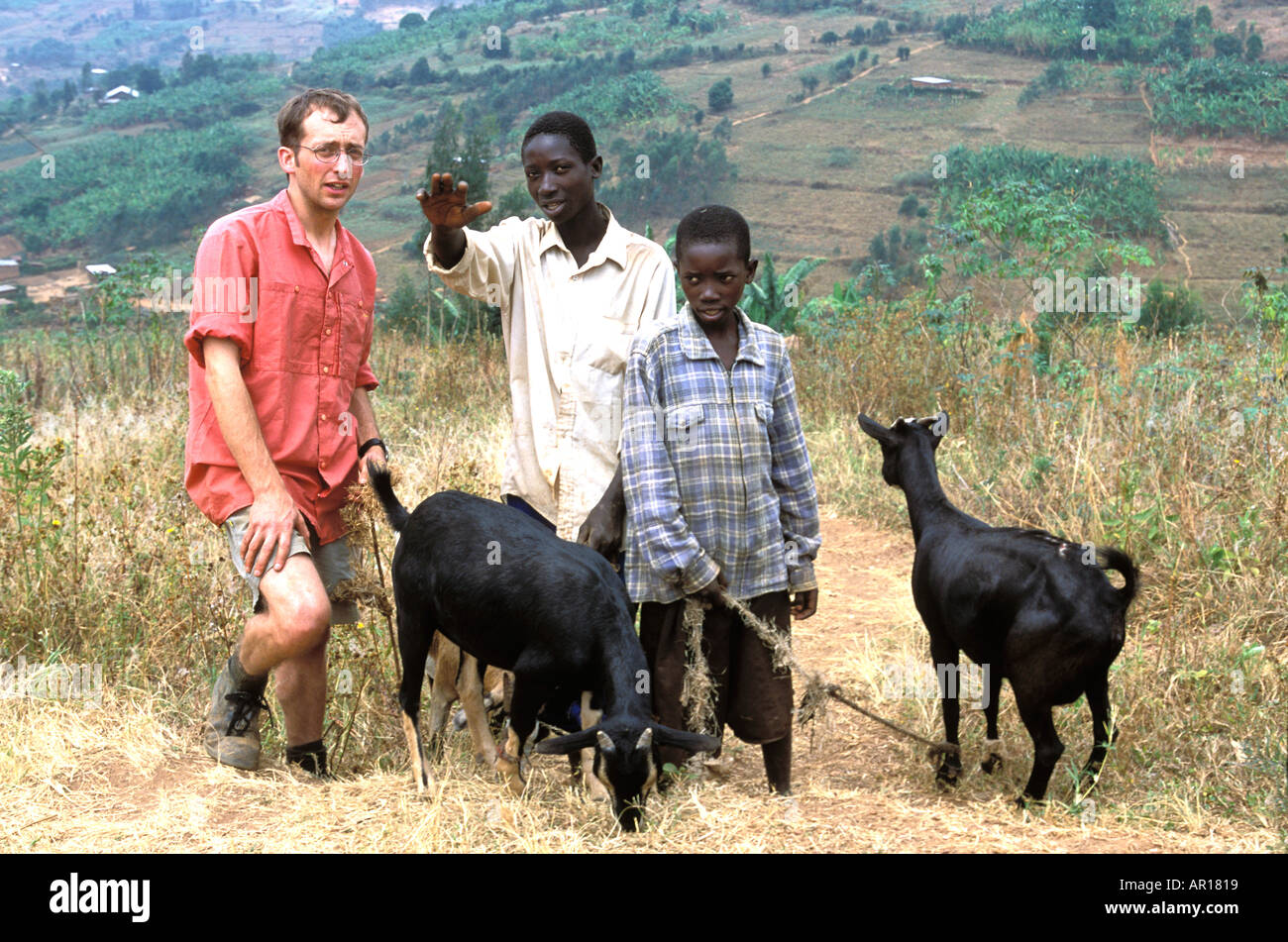 Rwanda Mark from UK Young Farmers helps genocide orphan Theogene with a gift of goats to child headed household  Stock Photo