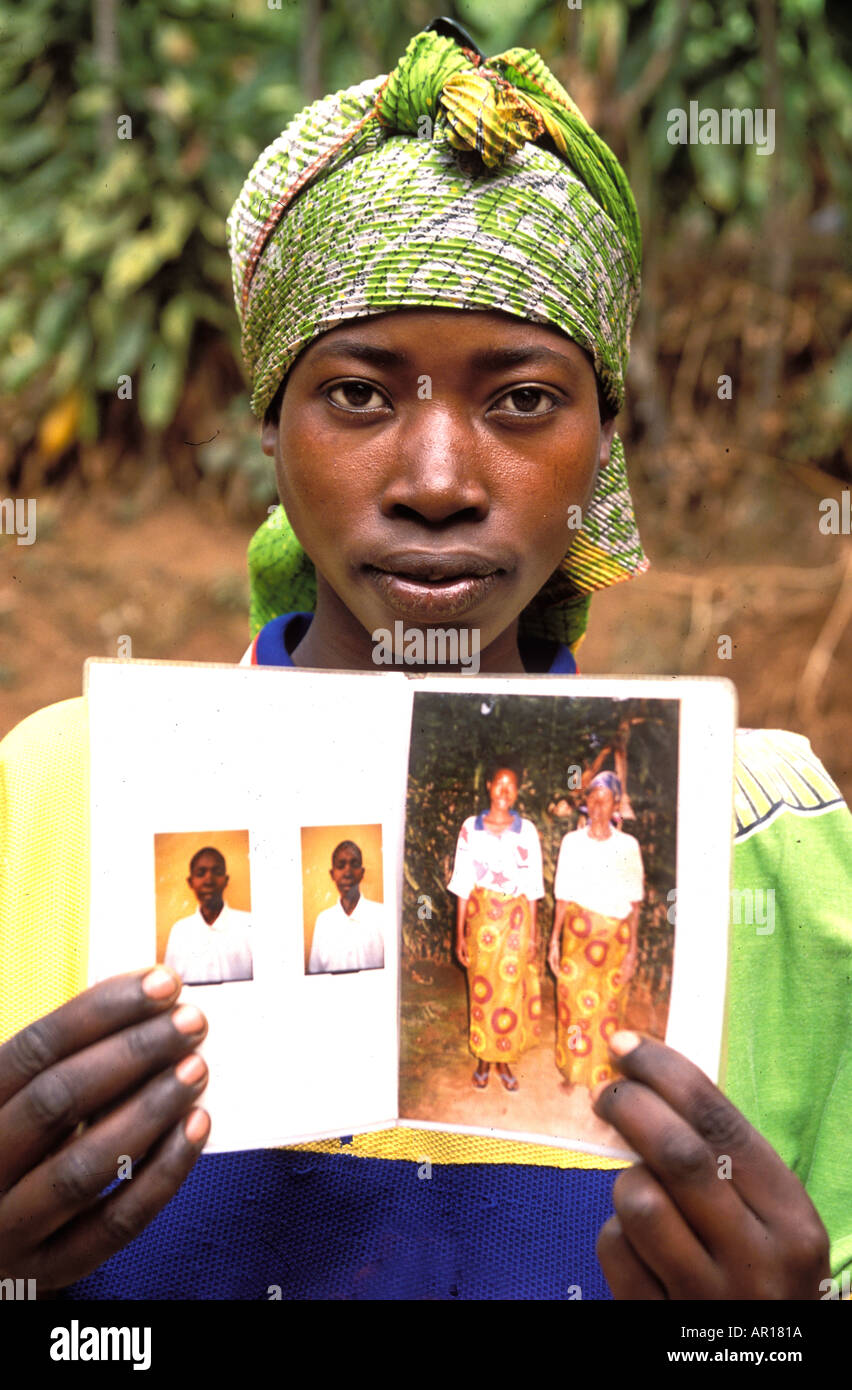 Rwandan genocide orphan Leonile shows pictures of her parents uncle aunt who were killed by machete in their home  Stock Photo