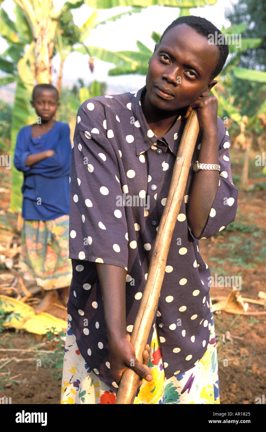 Rwandan genocide orphan Eugenia is mother father to her younger siblings works in fields walks 8km per day to get water Stock Photo