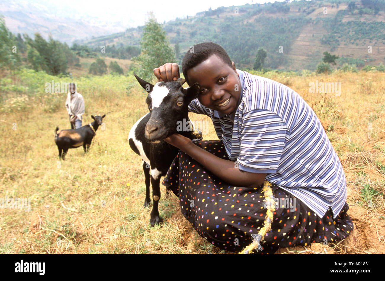 Rwanda genocide orphan Sylvie who looks after her younger siblings is given a goat by Send a Cow  Stock Photo