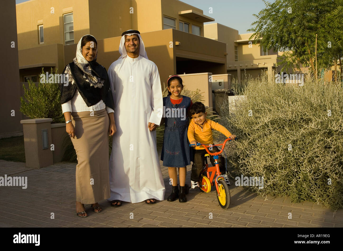 Family of four standing outside their home Stock Photo - Alamy