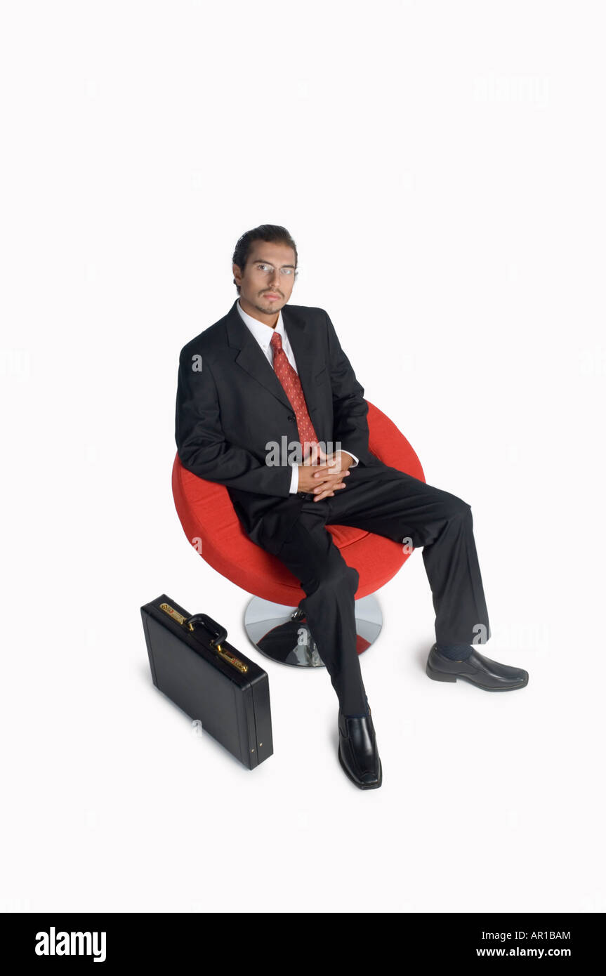 Businessman sitting on chair, portrait Stock Photo - Alamy