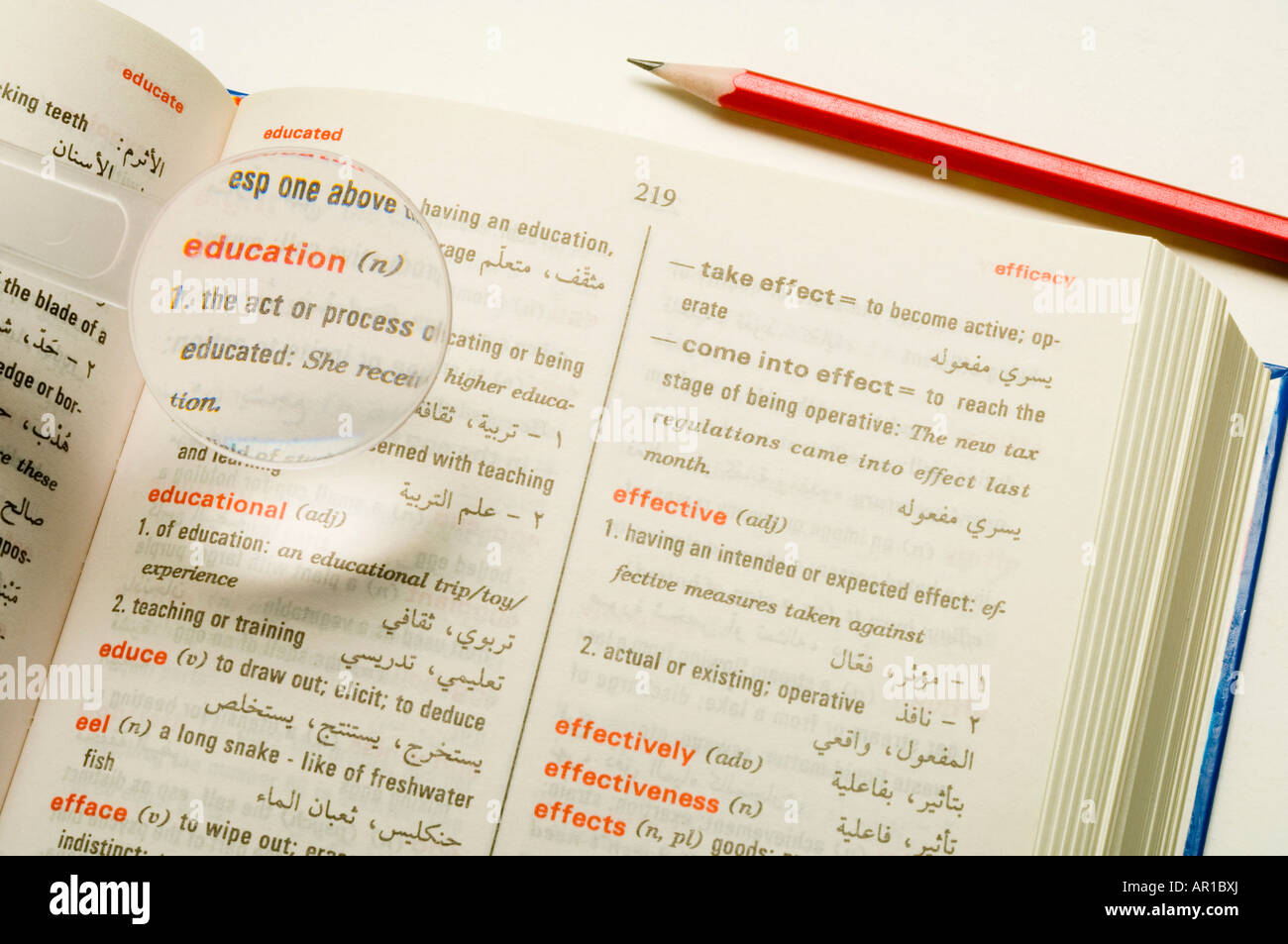 Magnifier on dictionary, closeup, elevated view Stock Photo Alamy