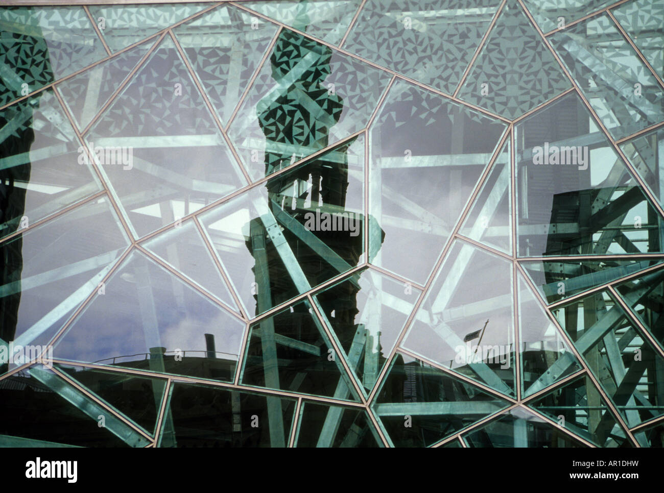 The tower of a building in central Melbourne reflects in the facade of another building, across the street from it. Stock Photo