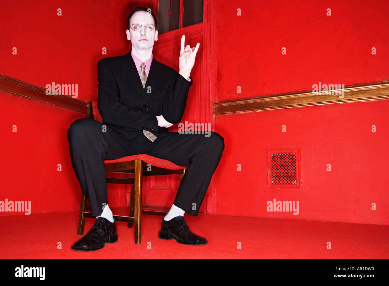 indoor room wall walls door red man 40 45 mature vampire dark haired suit chemise pink tie black business businessman whey fa Stock Photo