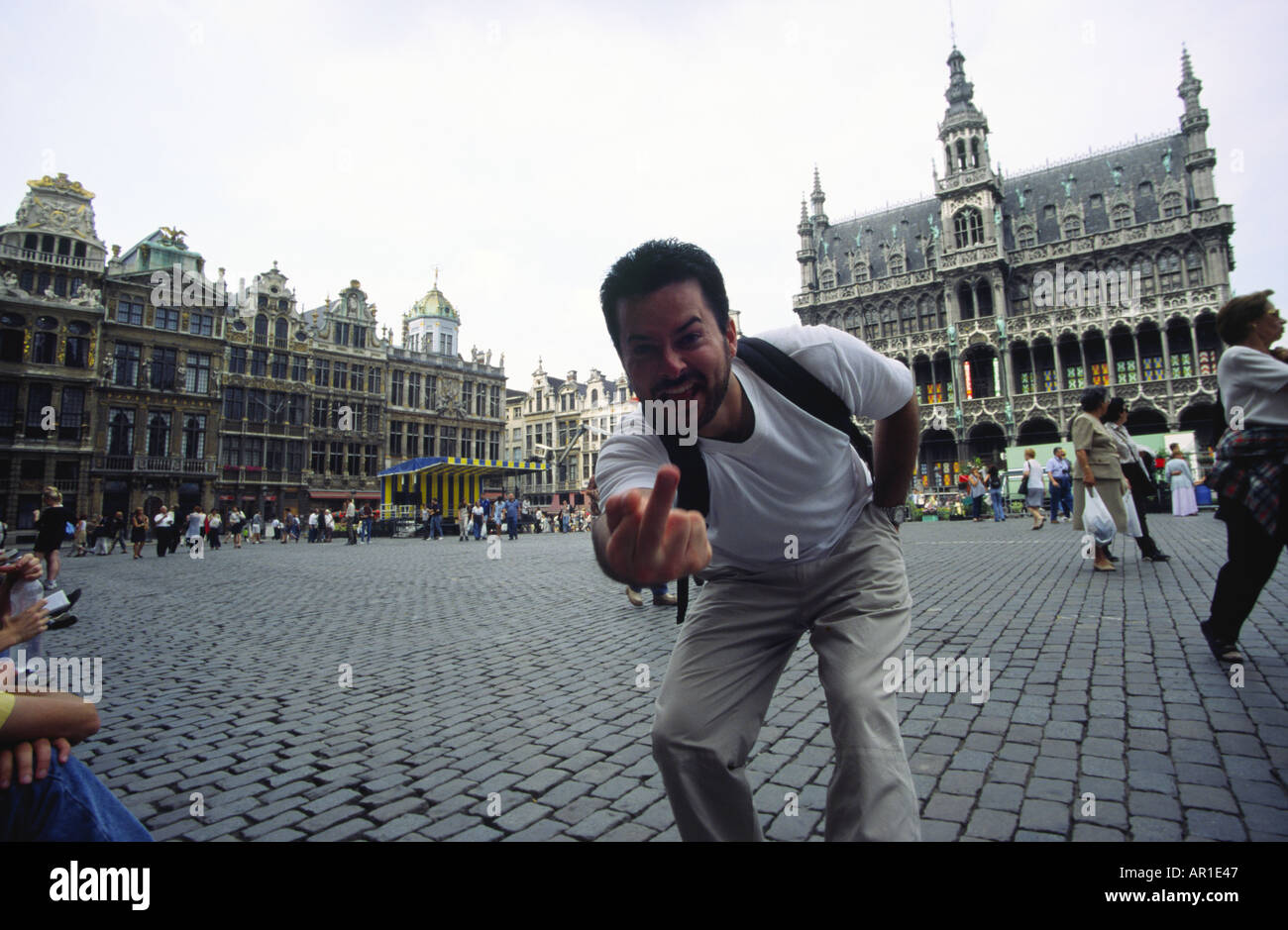 Man sticks his finger up rudely in the grand place Stock Photo