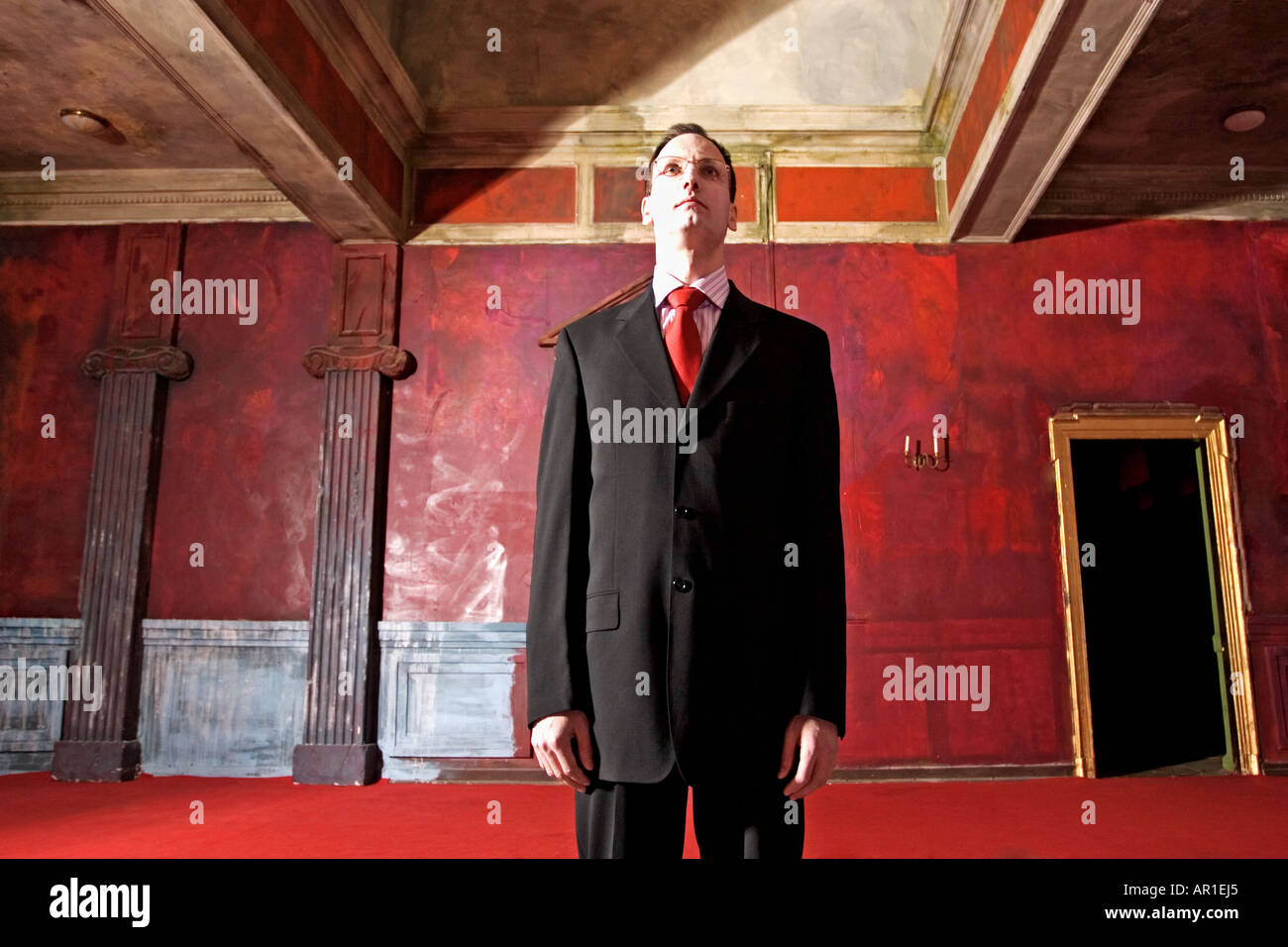 indoor room wall walls door red man 40 45 mature vampire dark haired suit  chemise pink tie black business businessman whey fa Stock Photo - Alamy