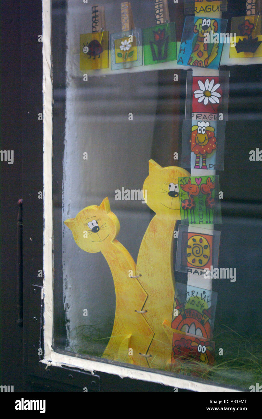 Two curious yellow wooden cats look out of a Golden Lane shop window at ...