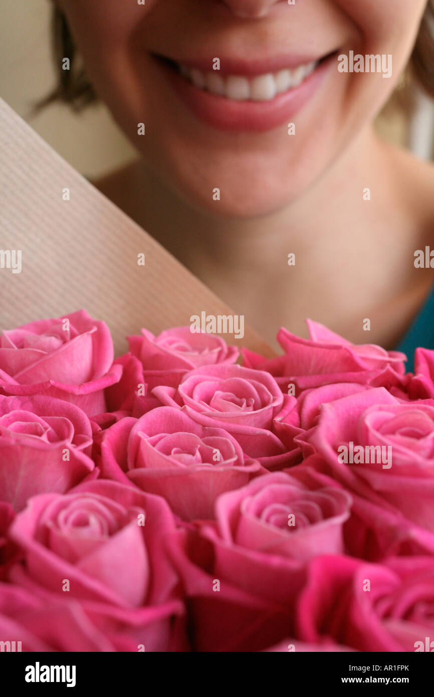 Woman smiling over a bunch of flowers Stock Photo - Alamy