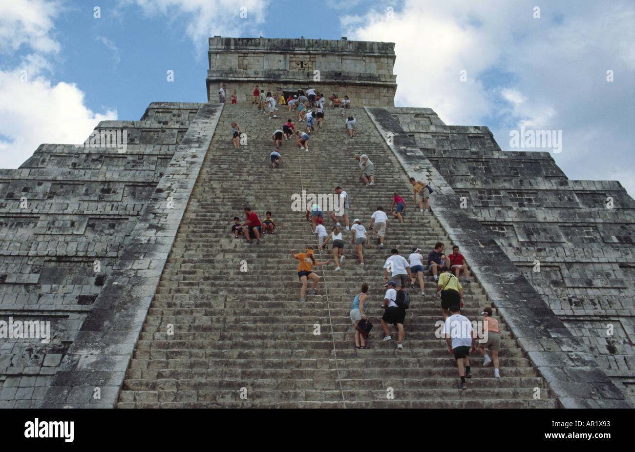 Tourists climbing the steep stairs of El Castillo Pyramid at Chichen