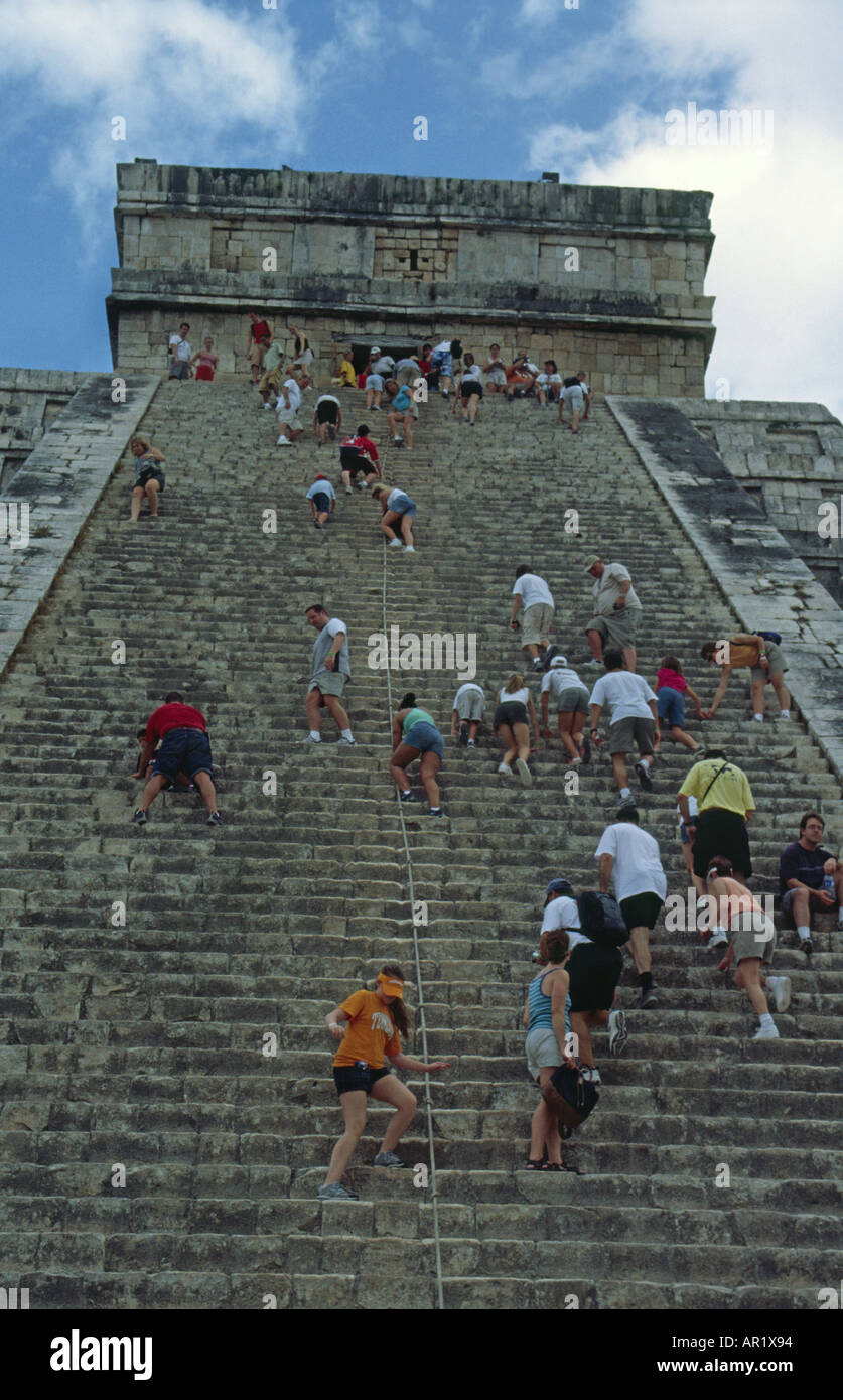 Tourists climbing the steep stairs of El Castillo Pyramid at Chichen