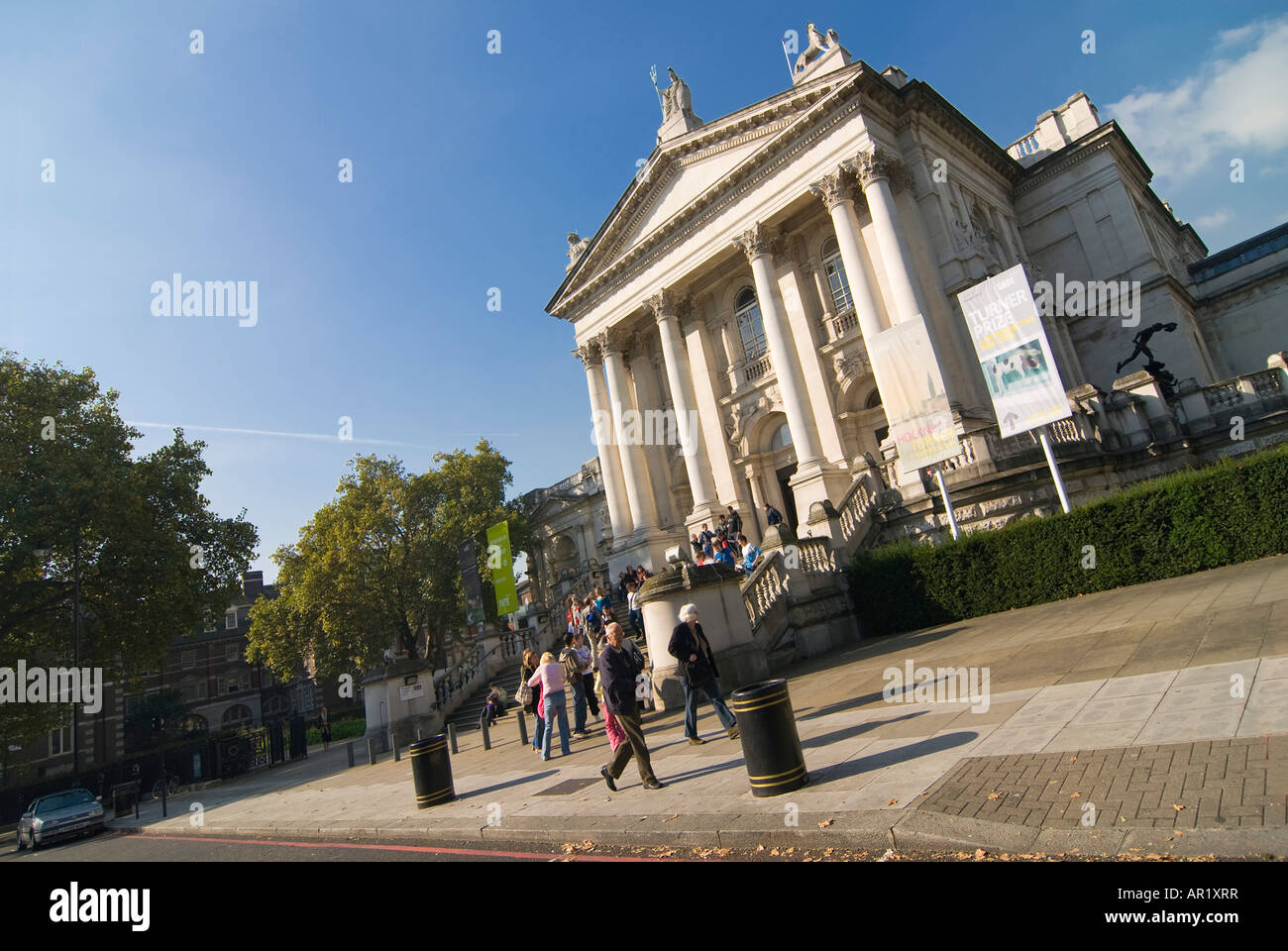 Horizontal angular wide angle of tourists outside the front entrance of the Tate Britain Gallery on a bright sunny day. Stock Photo