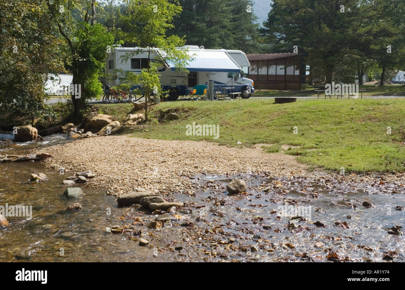 Motorhome camper parked beside creek in private mountain campground in