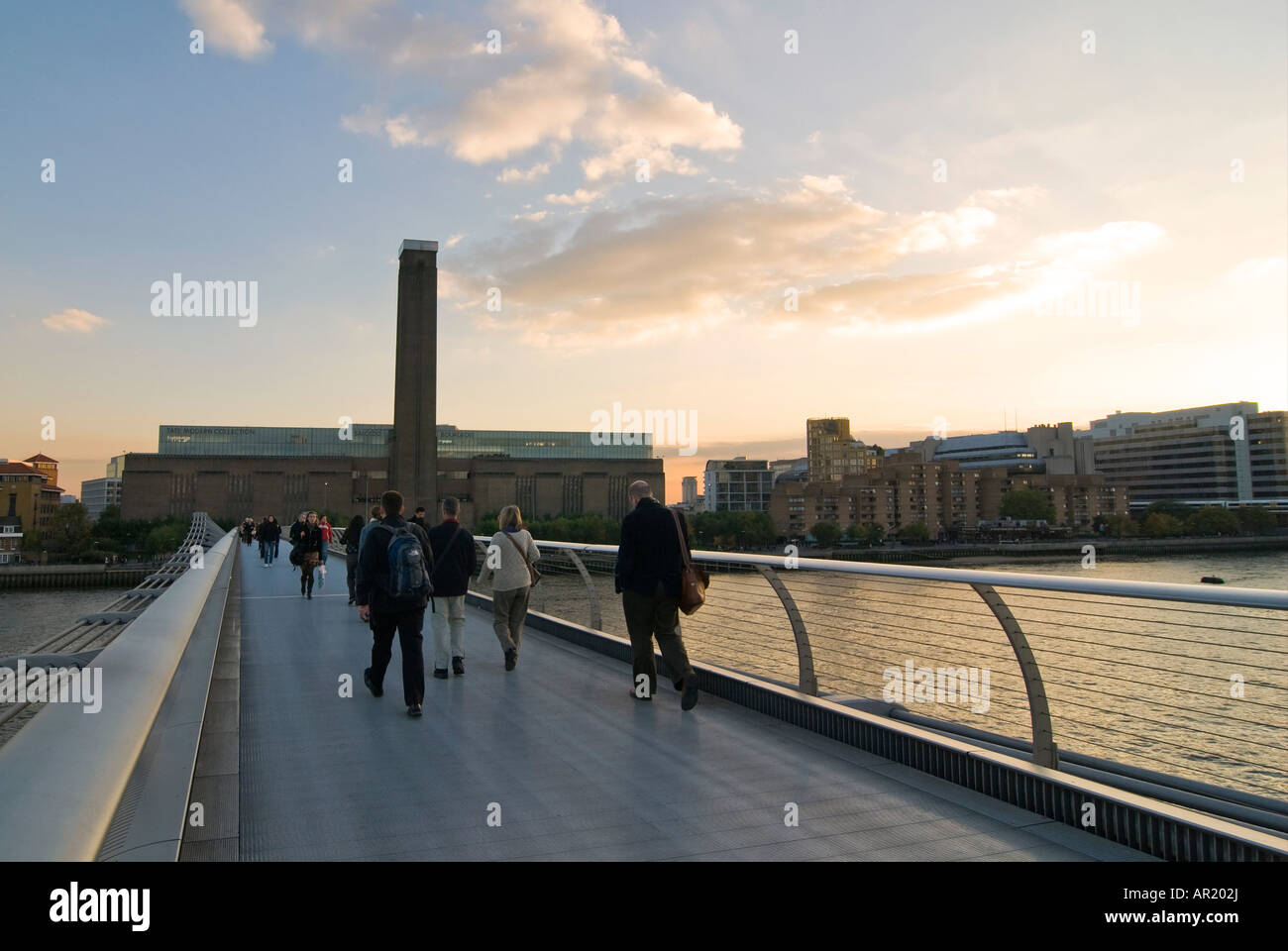 Horizontal wide angle of the Tate Modern museum and the Millennium Bridge crossing the river Thames at sunset. Stock Photo