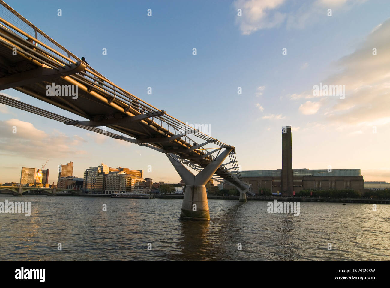 Horizontal wide angle of the Tate Modern museum and the Millennium Bridge crossing the river Thames at sunset. Stock Photo