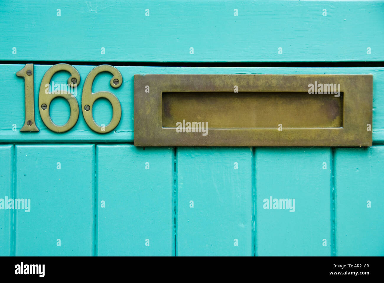 Close-up of brass letterbox in brightly coloured door of number 166 Stock Photo