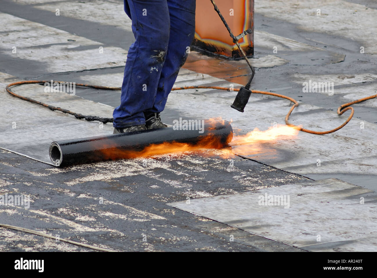 Worker preparing a roof for a new tar sheeting layer using a gas burner Stock Photo Alamy