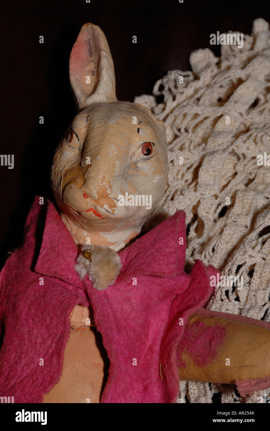 Antique bunny doll on lace afghan sitting on a couch Stock Photo