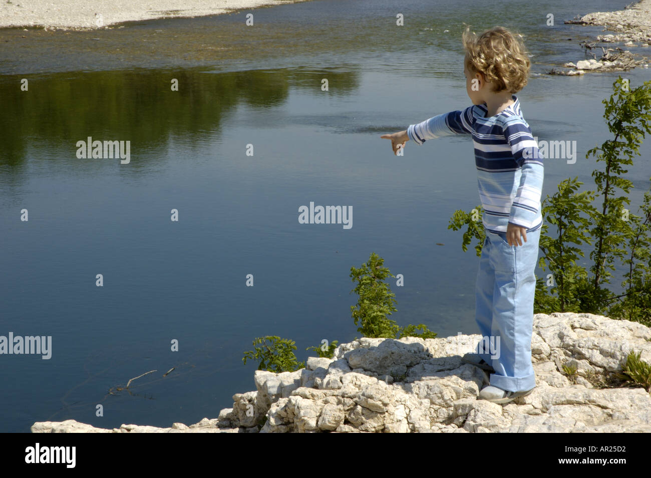 Little girl pointing at the surface of the Gardon river, Provence, France. Stock Photo