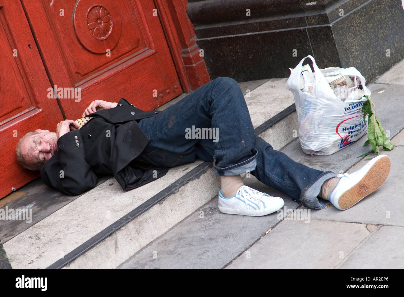 Homeless man sleeps in pub doorway London Stock Photo