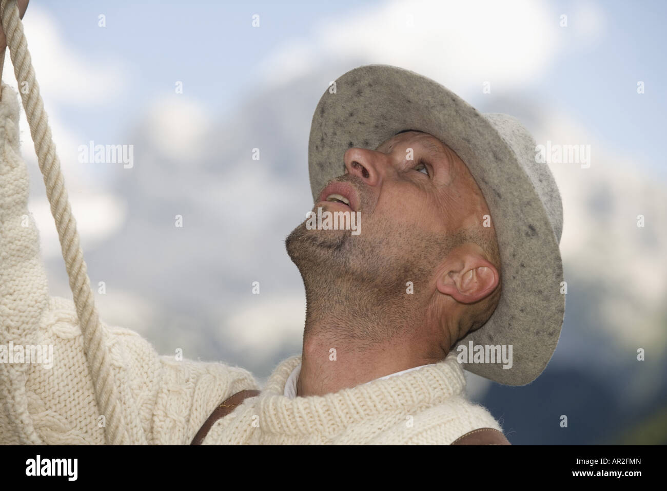 historic mountain climber in traditional clothing with climbing rope ...