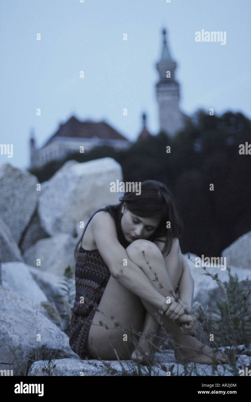 young woman sitting on stone Stock Photo