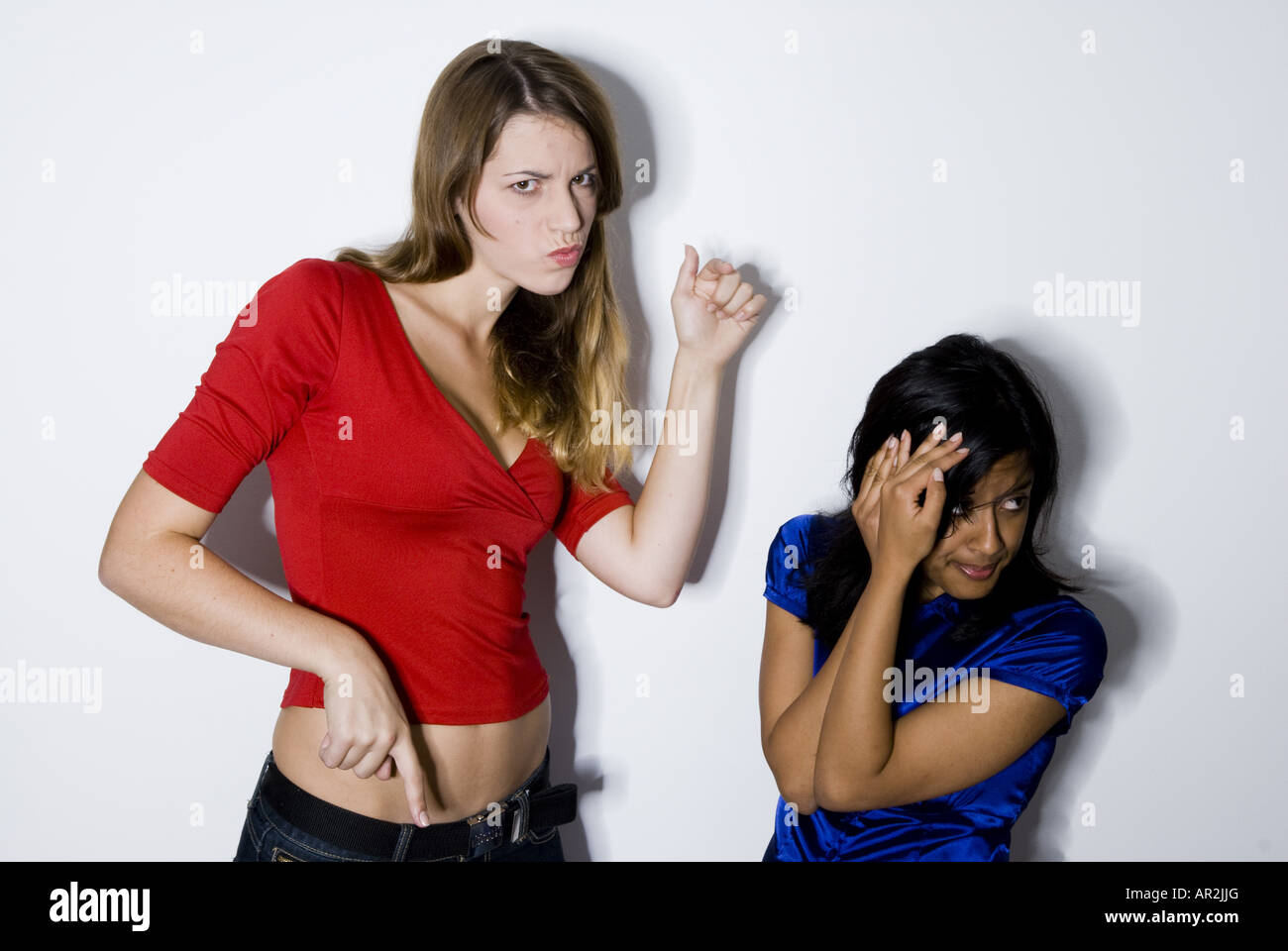 two young women, one aggressiv, the other fearful Stock Photo