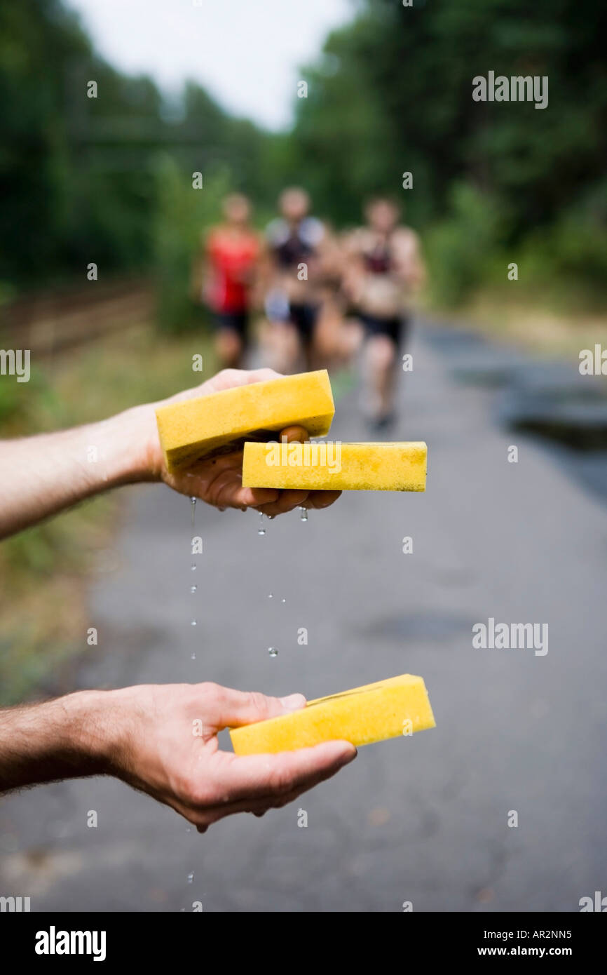Wet sponges for athletes running in triathlon Stock Photo