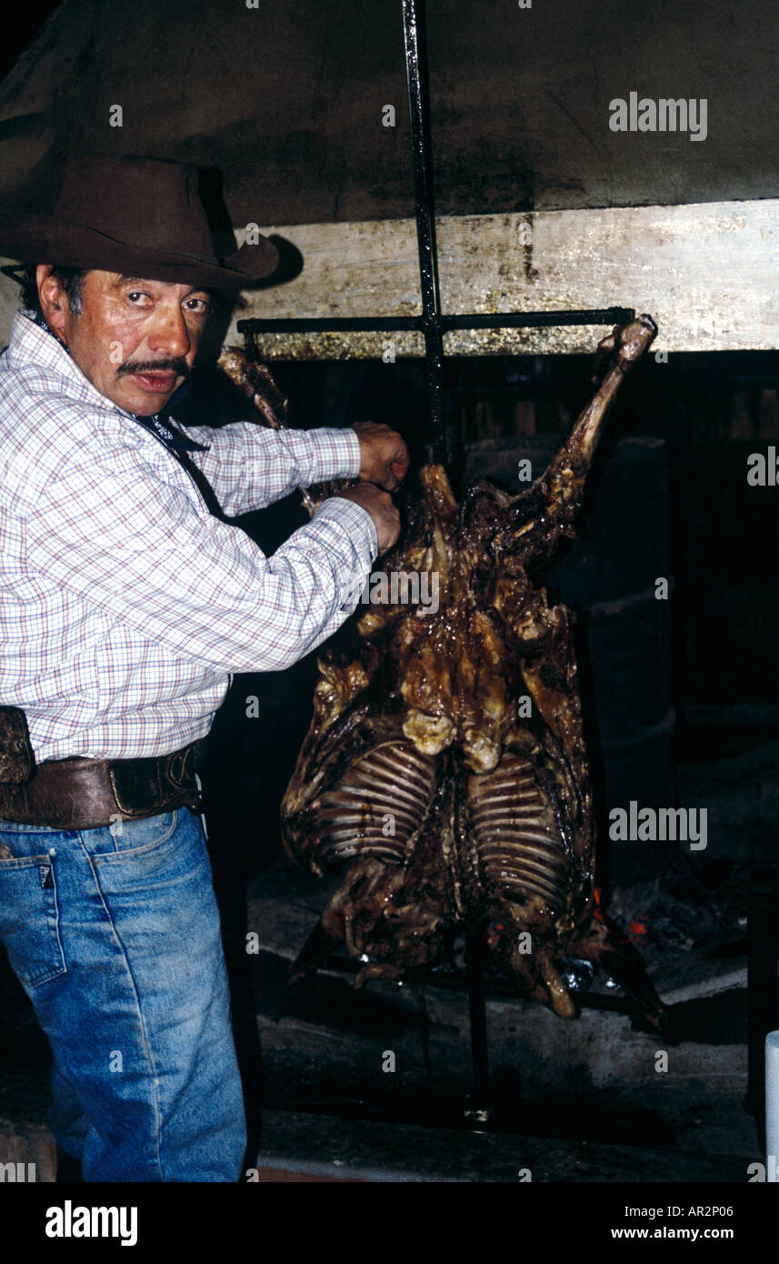 Gaucho cowboy tending to typical Patagonian (lamb) barbeque - an 'asado,' Torres de Paine National Park, Chile, South America. Stock Photo