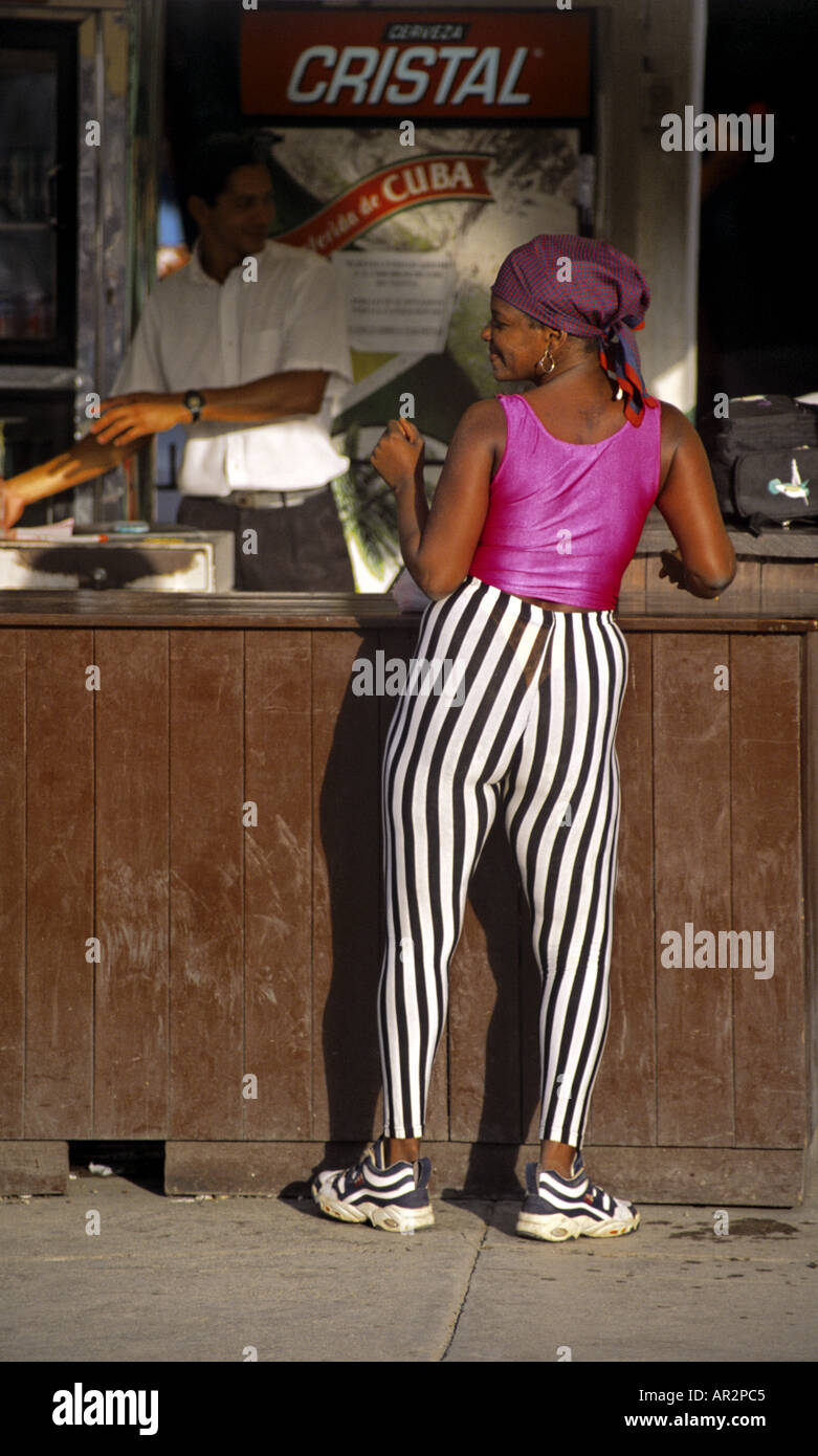 Woman with bandana and black & white striped spandex pants shakes her behind at street bar, Havana, Cuba. Stock Photo