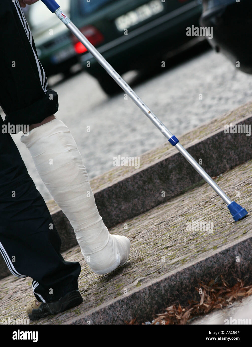 Stepping out. an young man with one leg walking on crutches in a