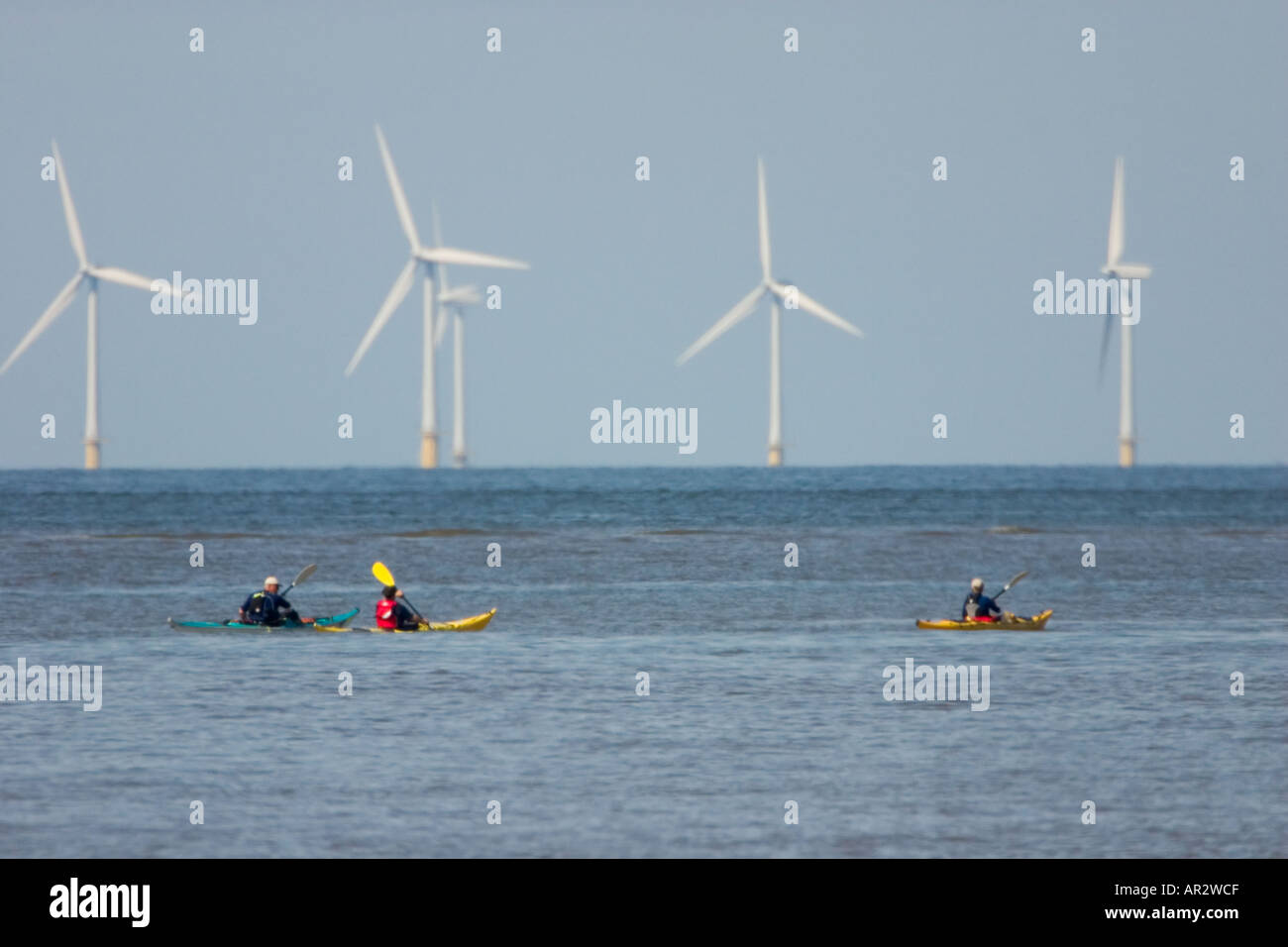 Wind farm off the coast of North Wales with sea canoeists Stock Photo