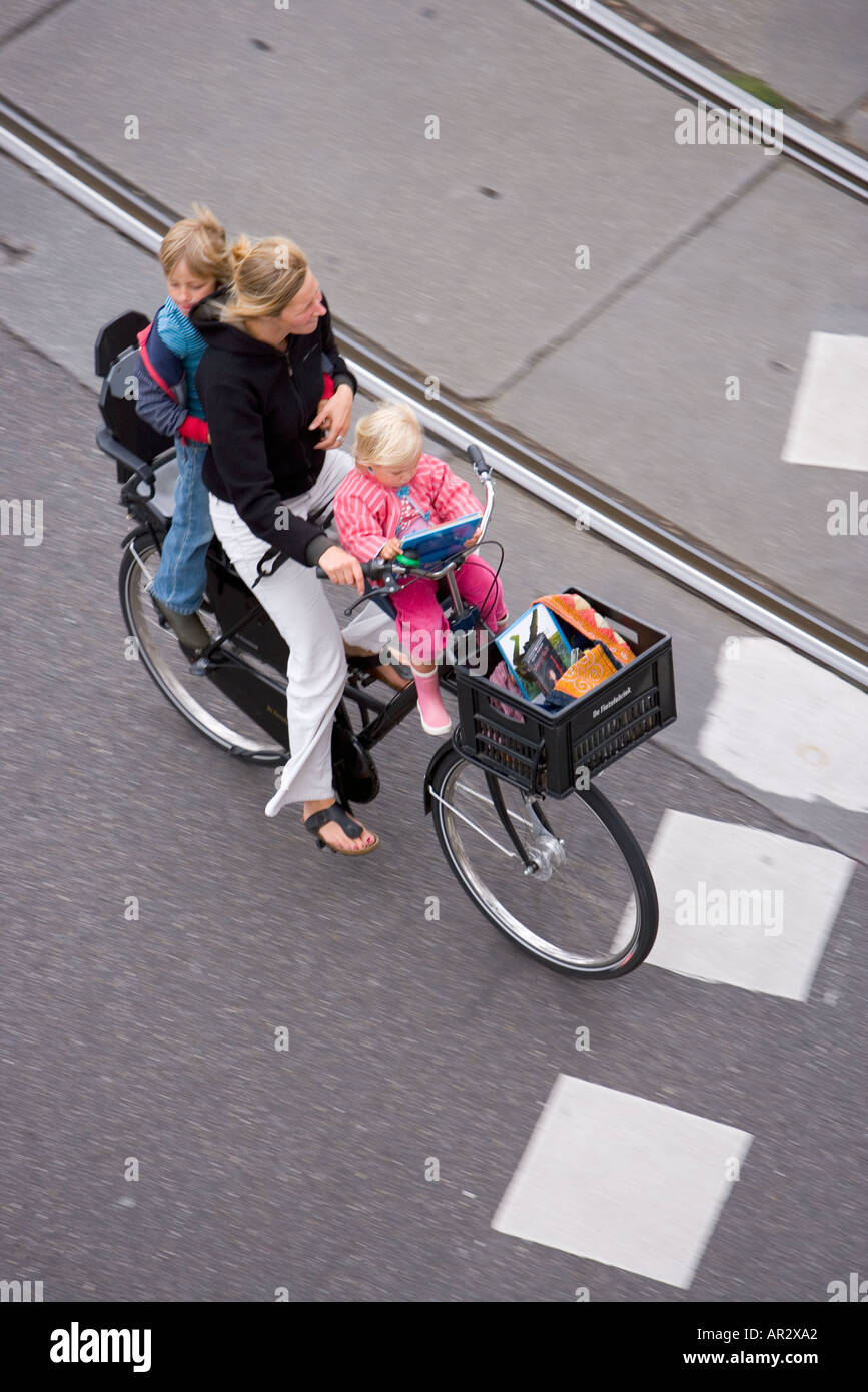 HOLLAND AMSTERDAM MOTHER CARRYING TWO CHILDREN ON A BIKE WITH SHOPPING