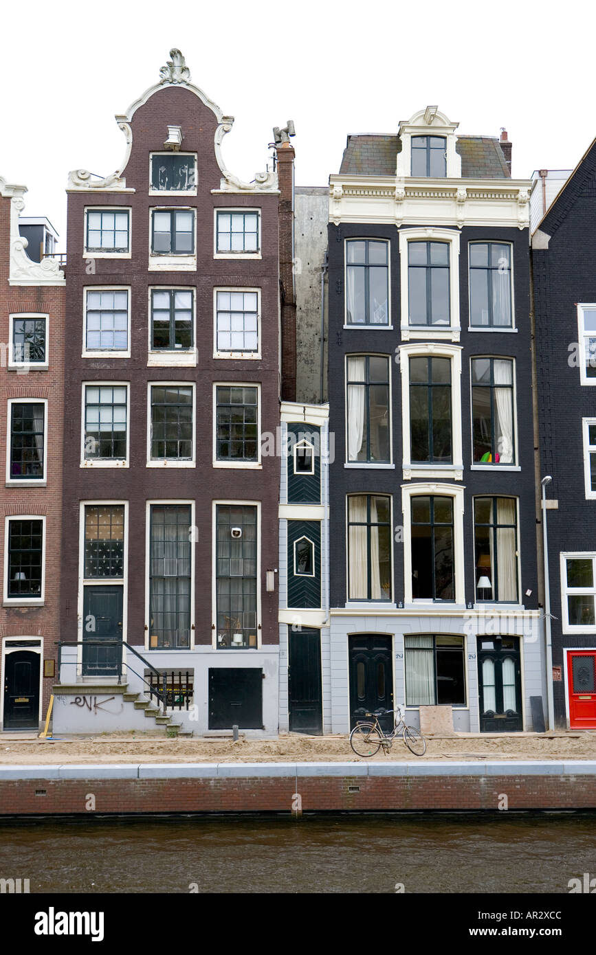 HOLLAND AMSTERDAM ROW OF OLD CANAL SIDE HOUSES WITH ONE VERY NARROW