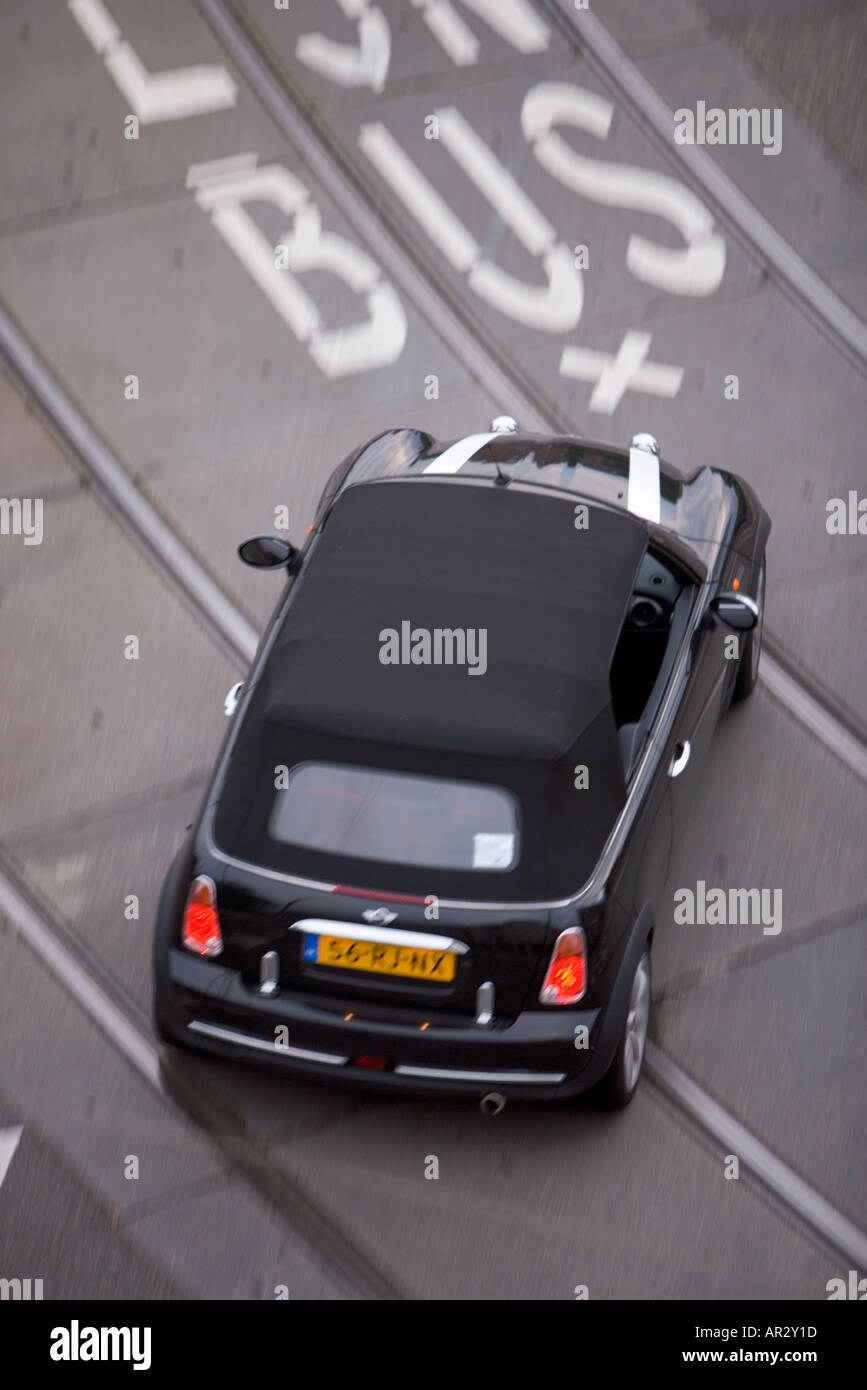 HOLLAND AMSTERDAM OVERHEAD VIEW OF BLACK CONVERTIBLE MINI IN BUS AND TRAM LANE Stock Photo