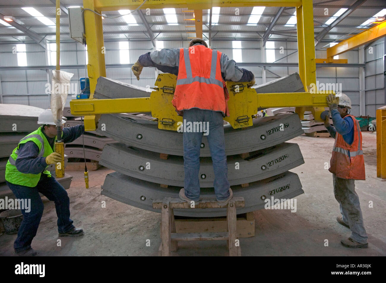 Using special handling equipment, fabrication operatives stack a complete 'ring' of reinforced