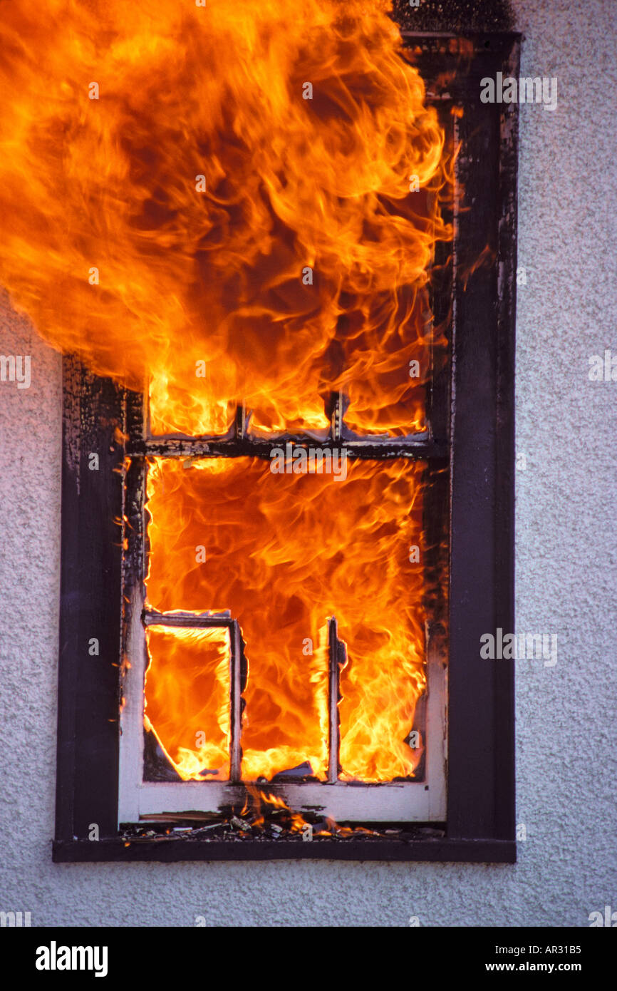 Flames shooting out of window of burning home 1909 008 36 Stock Photo