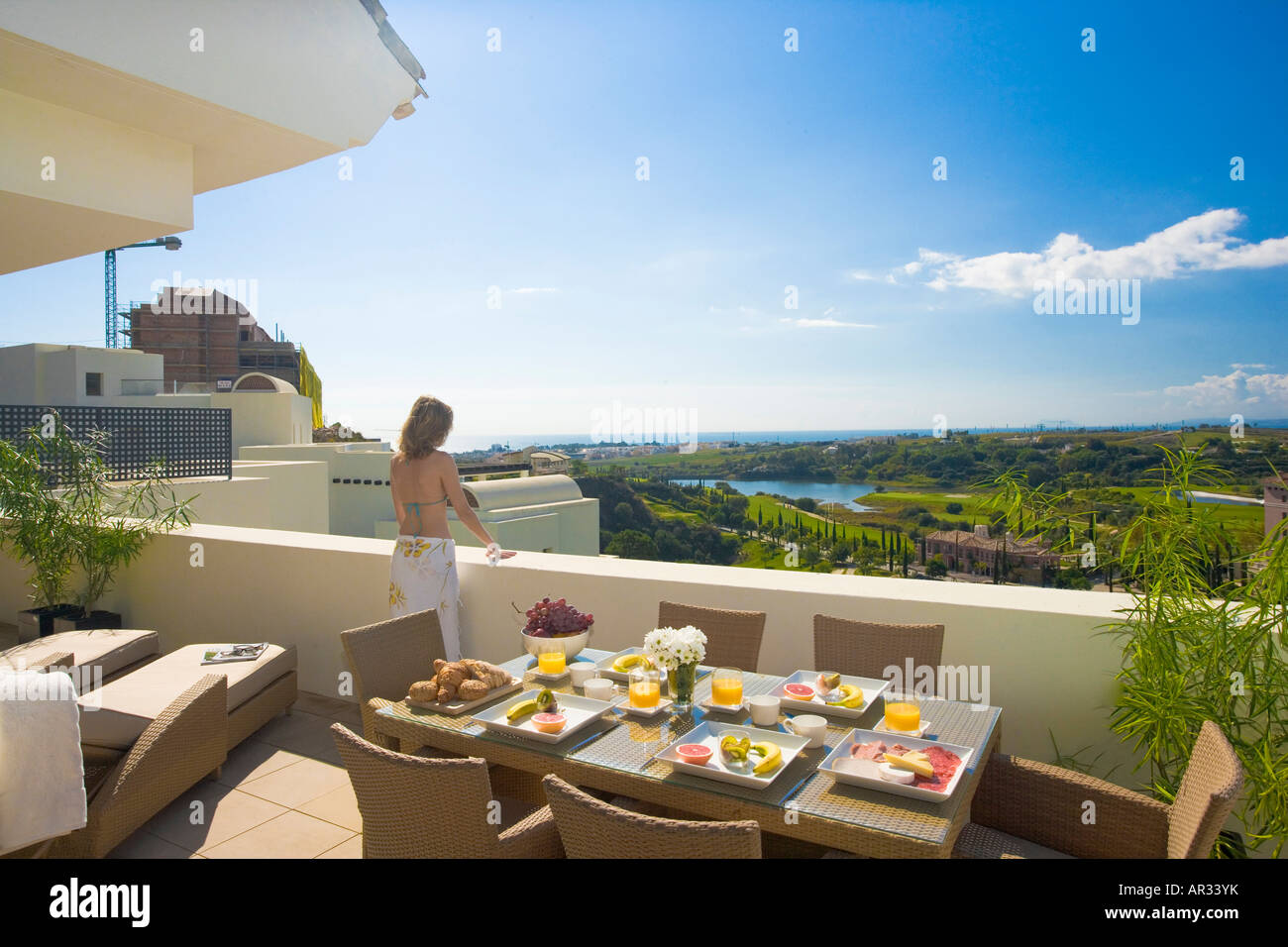 Image showcasing Spain, young woman on balcony of apartment looking over golf course and ...