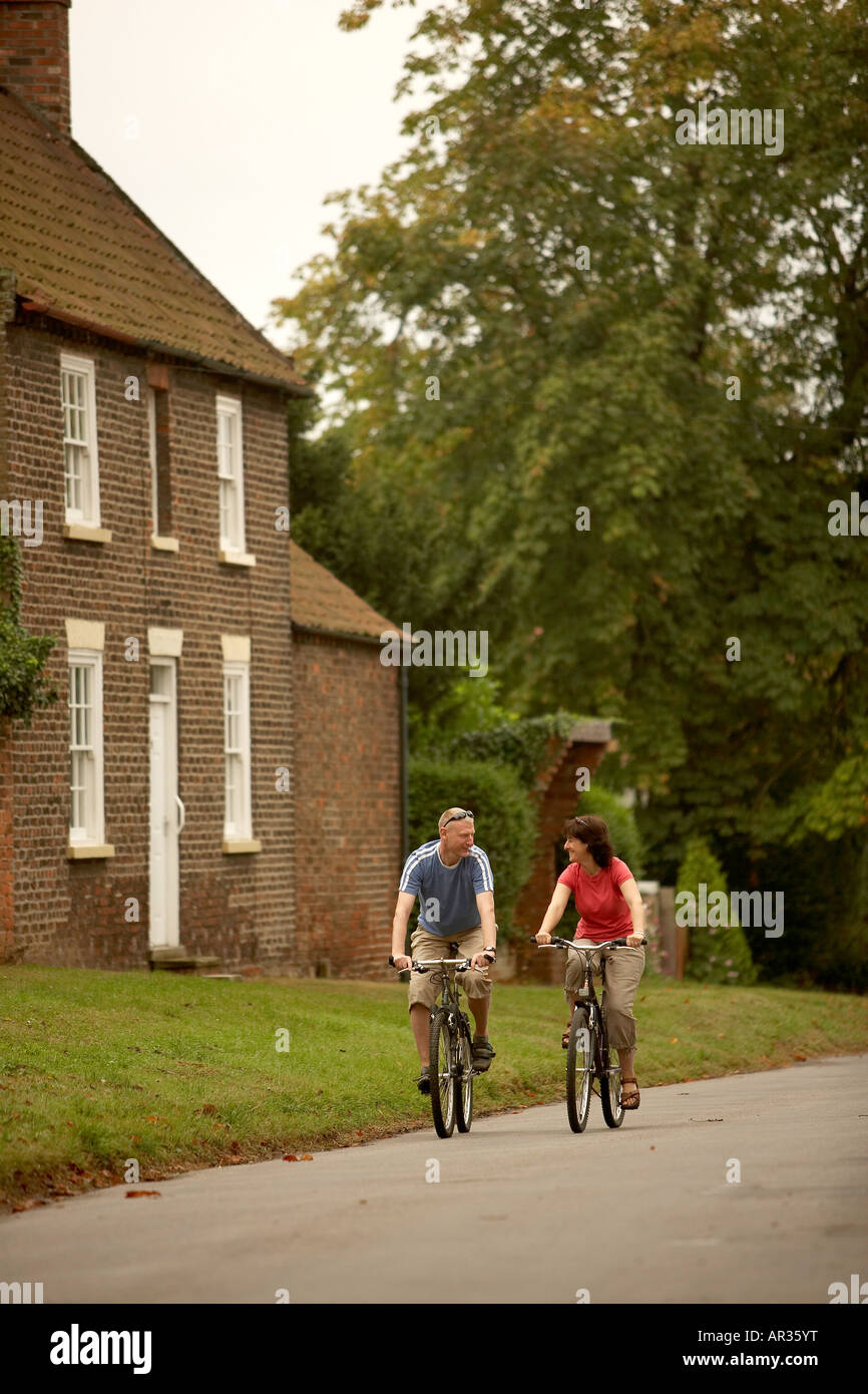 Couple cycling in the countryside the wolds South Dalton East Yorkshire UK Stock Photo