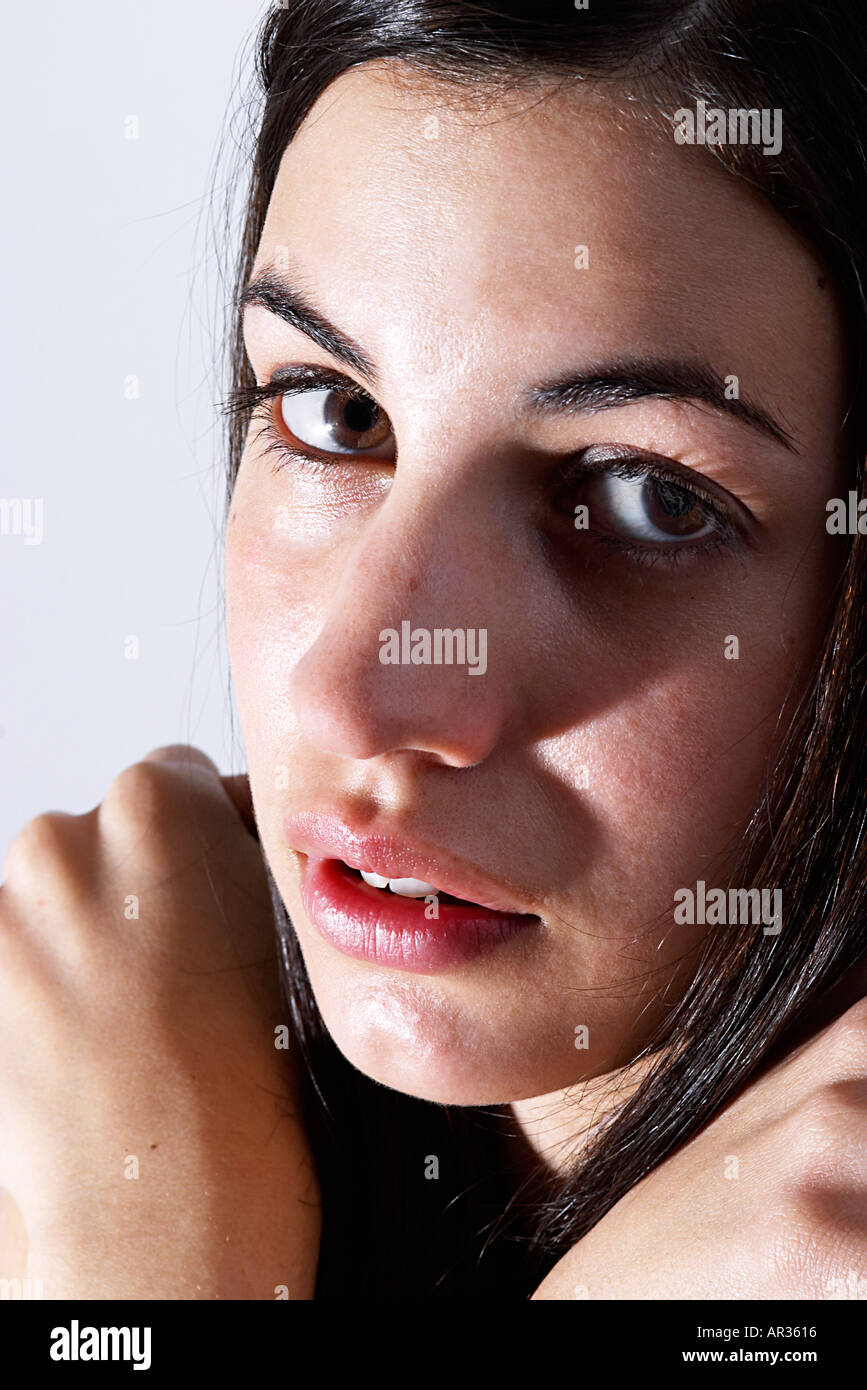color-headshot-of-young-black-haired-woman-hugging-her-shoulders-and