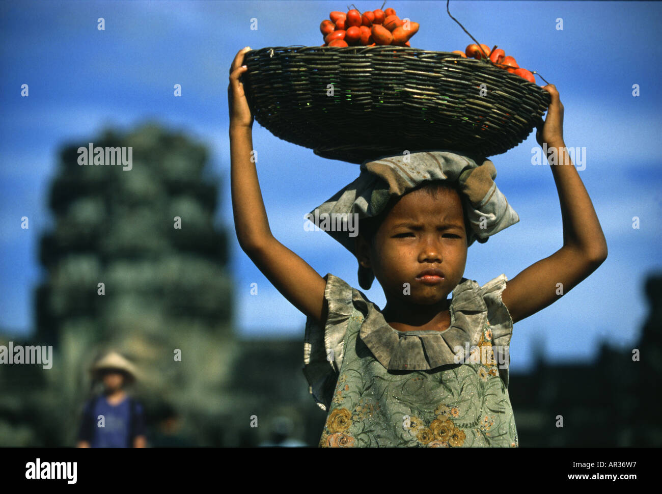 Girl carrying a basket of fruit on her head, Angkor Wat, Siem Raep
