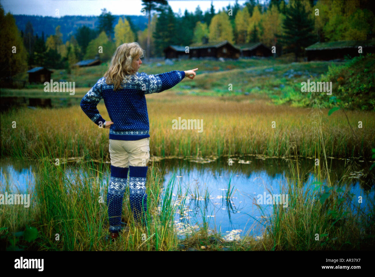 Norwegian woman standing in front of a pond, Maihaugen, Lillehammer, Norway, Scandinavia, Europe Stock Photo