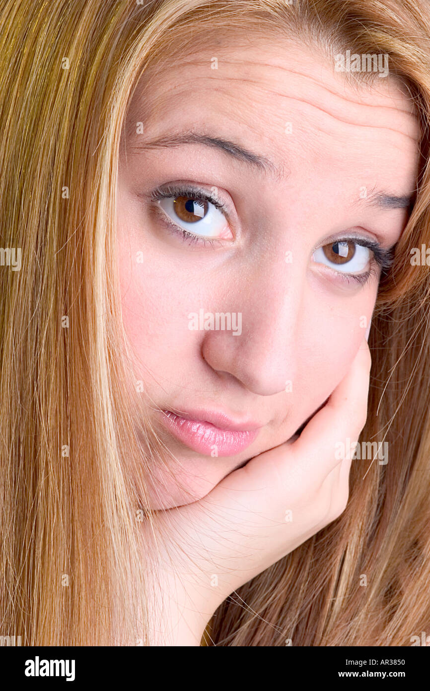 Headshot of young blonde woman with chin resting on her hand and bored