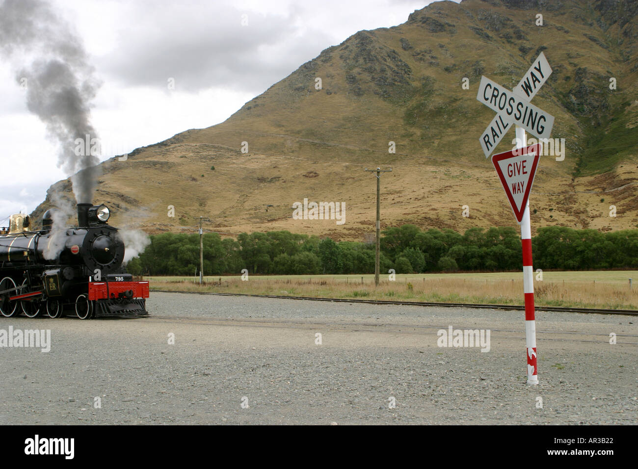 Railway crossing and Give Way Sign with steam train Kingston Flyer New Zealand Stock Photo
